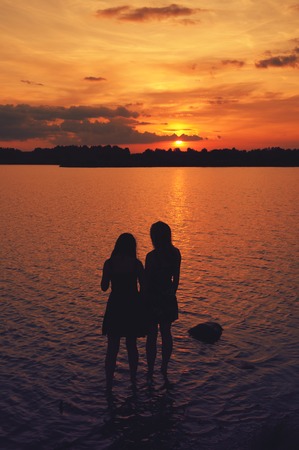 girlfriend on the beach having fun at sunset in summerの写真素材