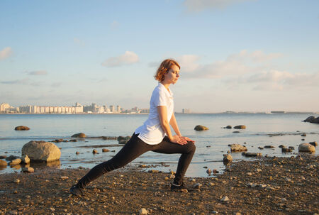 beautiful woman doing yoga exercises on the beach