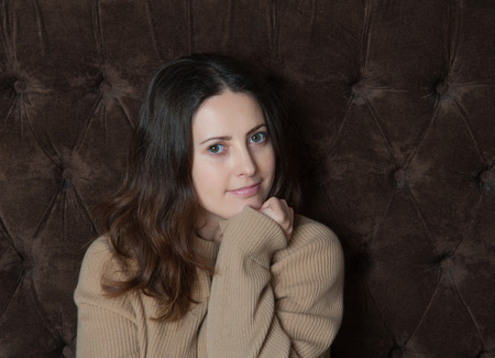 beautiful mature woman sitting on sofa, smiling