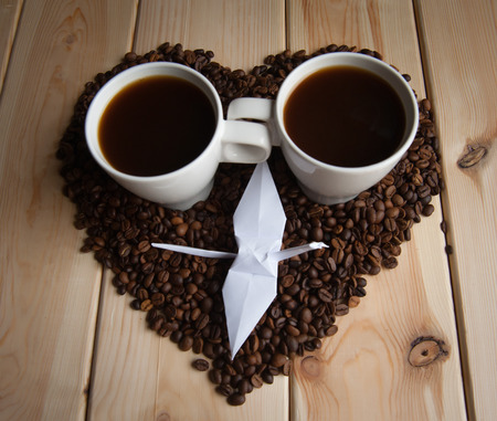 Cup of coffee with crane origami on the coffee beansの写真素材