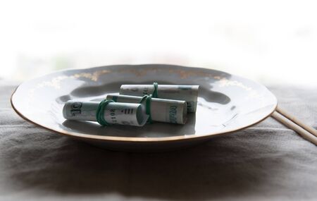 sushi in the form of money lying on the table with a tablecloth