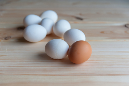 eggs of different color lie on a wooden tableの写真素材