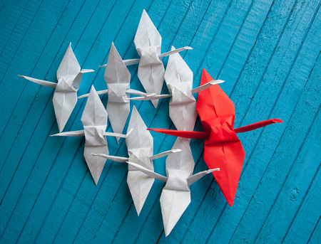 lot of white cranes and 1 red on the boardの写真素材