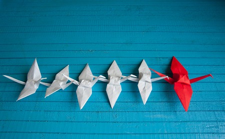 lot of white cranes and 1 red on the boardの写真素材