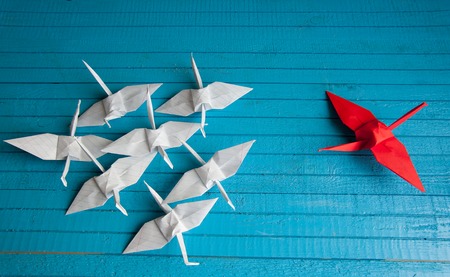 lot of white cranes and 1 red on the boardの写真素材