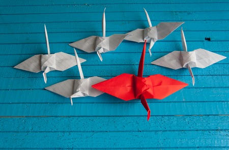 lot of white cranes and 1 red on the boardの写真素材