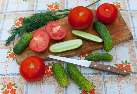 tomatoes,cucumbers and dill lying on the tableclothの写真素材