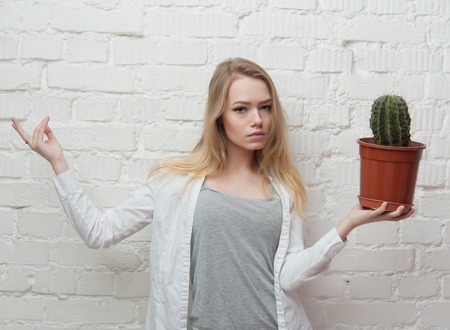 girl with cactus in the pot at the white wallsの写真素材