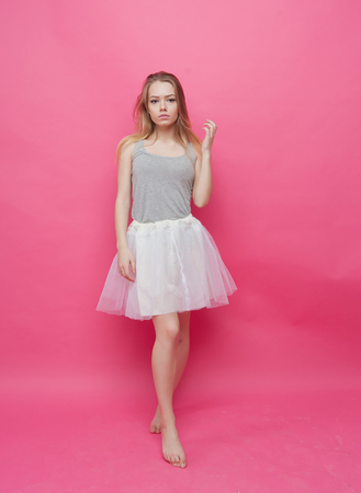 barefoot girl dancing ballet on pink backgroundの写真素材