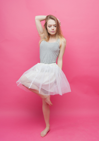 barefoot girl dancing ballet on pink backgroundの写真素材