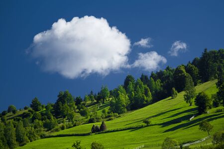 White cloud on a blue sky in a green countryside of Romaniaの写真素材