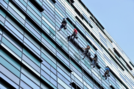 Five window cleaners washing an office buildingの写真素材
