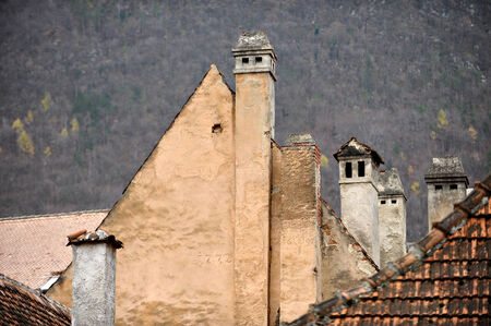 Old chimneys and old houses with autumn scenery in backgroundの写真素材