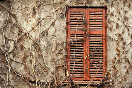 Abandoned house detail with old wooden window and shutters closedの写真素材