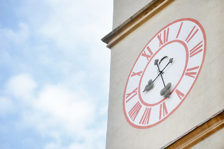 Architecture detail with old church clock tower and blue sky on backgroundの写真素材