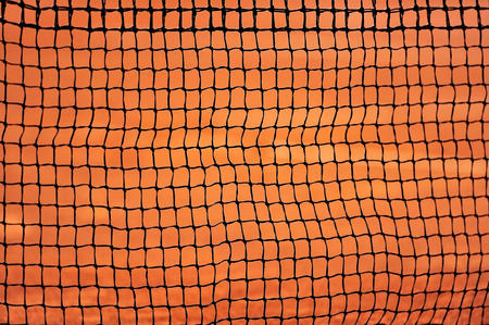 Sport detail shot with a tennis net on a clay courtの写真素材