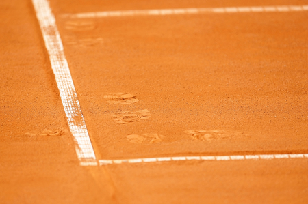 Detail with a baseline and footprints on a tennis clay courtの写真素材