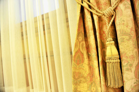 Detail shot with a yellow curtain decorative tasselの写真素材