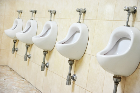 Detail with five white urinals in a public men's toiletの写真素材