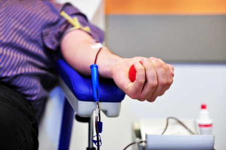 The hand of a blood donor squeezing a medical rubber ballの写真素材