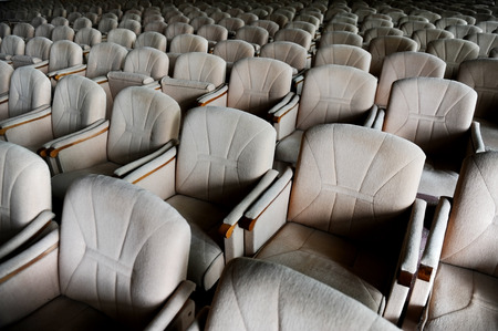 Rows with lots of empty beige velvet armchairs in a big conference room