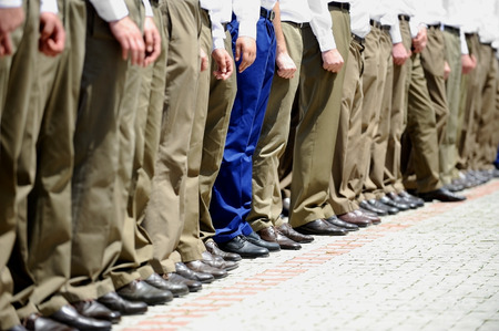 Blue military uniform stands out from a row of soldiers during military parade