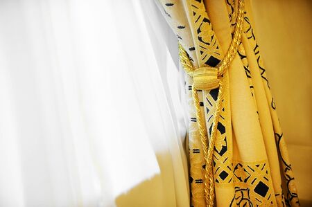 Luxury yellow window curtain with decorative tasselの写真素材