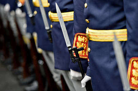 Detail with the hand of a soldier on a bayonet rifle in rest position during a military parade
