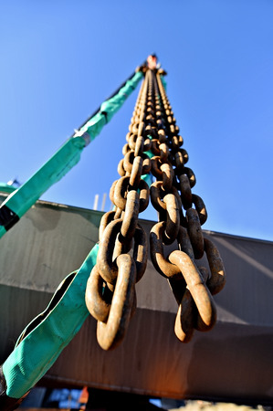 Heavy duty industrial chain hooked up on a construction crane