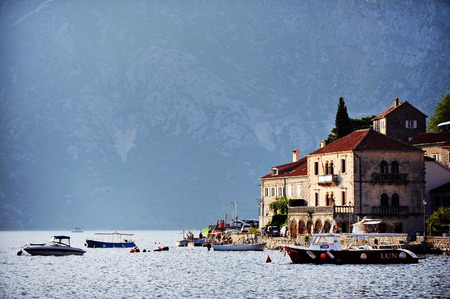 KOTOR, MONTENEGRO - AUGUST 24: Tourist boats are seen anchored in the Bay of Kotor with mountains in...