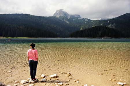 ZABLJAK, MONTENEGRO - AUGUST 26: Tourist rest on big stone on the shore of Black Lake on August 26, 2015 in Montenegro.のeditorial素材