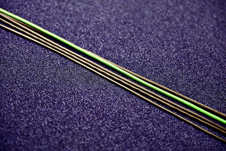 Detail with several electric cables on a blue carpet