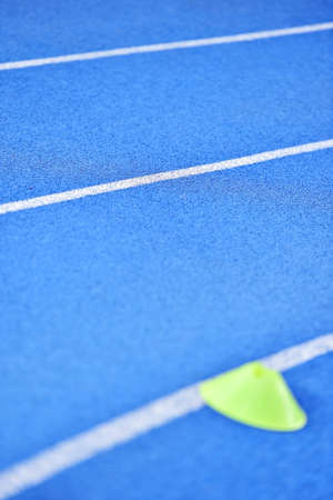 Athletics blue sprint track with yellow marker training cones