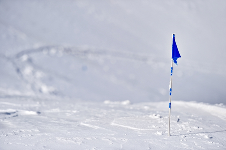 Blue flag blown by the wind on a mountain in winterの写真素材
