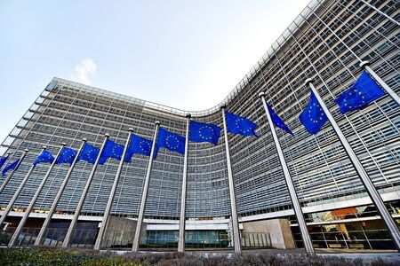 BRUSSELS, BELGIUM - MARCH 16: EU flags blown by wind in front of the European Commission Headquarters, also know as the Berlaymont building, on March 16, 2016 in Brussels.のeditorial素材