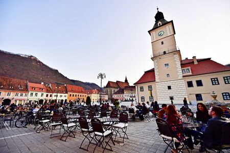 BRASOV, ROMANIA - APRIL 3: Tourists in a weekend day spending time in Sfatului Square, old town of Transylvania's medieval old town of Brasov, on April 3, 2016.のeditorial素材