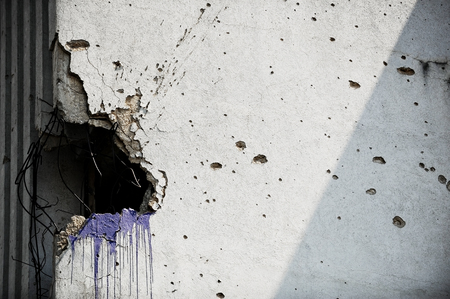 Traces of bullets on a building facade destroyed by war