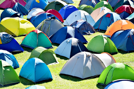 Lots of colorful tents on a meadow in a summer day during music festival