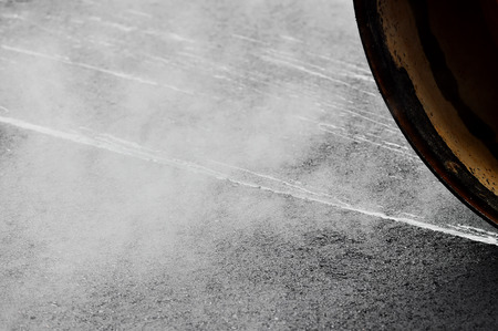 Asphalt paving with a steel wheel roller. Steam coming out from asphalt.の写真素材