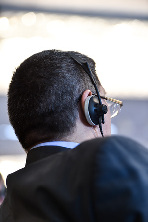 Unrecognizable business people using headphones for translation during eventの写真素材