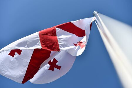 Georgia national flag blown by the wind against a blue sky