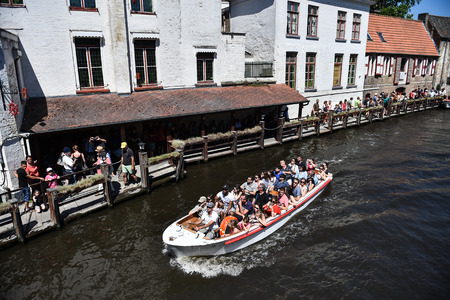 BRUGES, BELGIUM - MAY 26: Tourists taking a boat trip tour in Bruges on May 26, 2017.のeditorial素材