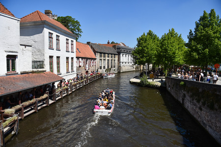 BRUGES, BELGIUM - MAY 26: Tourists taking a boat trip tour in Bruges on May 26, 2017.のeditorial素材