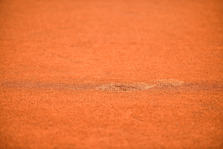 Detail with sport shoe footprints on a tennis clay courtの写真素材