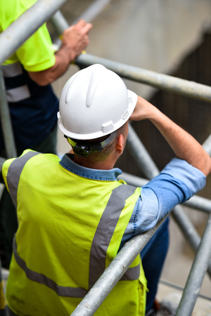 Workers inspecting construction works on a scaffold inside construction siteの写真素材