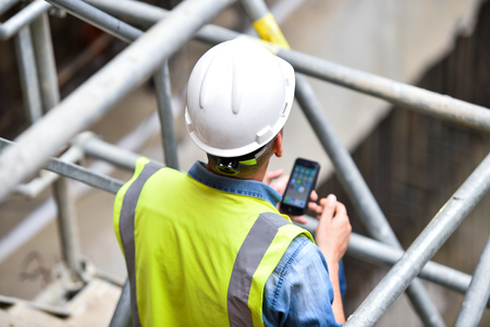 Workers inspecting construction works on a scaffold inside construction siteの写真素材