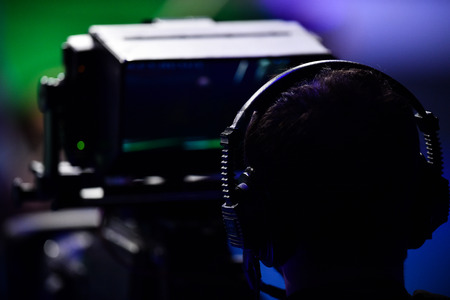 Cameraman filming inside a news television setの写真素材