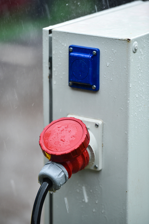 Raindrops are seen on industrial electric plug during heavy rainの写真素材