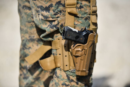 Pistol detail and military camouflage uniform on a soldierの写真素材