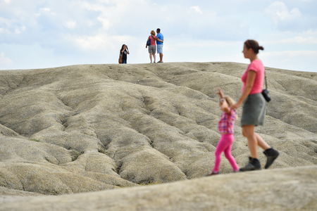 BUZAU, ROMANIA - AUGUST 13, 2016: Groups of tourists visiting mud volcanoes also known as mud domes in summer season.のeditorial素材